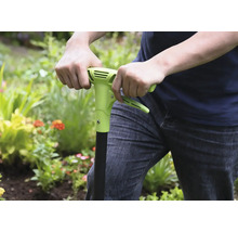 Osoba používa v záhrade plečku.