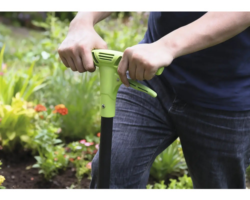Osoba používa v záhrade plečku.