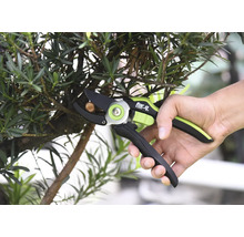 Osoba strihá konár záhradníckymi nožnicami značky For Q.