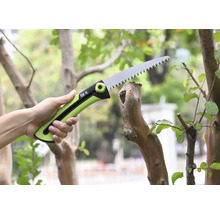 Záhradná pílka odreže konár.