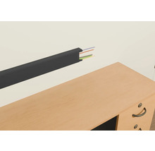 Plastový káblový kanál s káblami na stene nad stolom