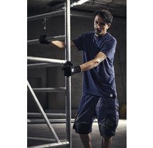 Muž v pracovnom odeve obsluhuje lešenie.