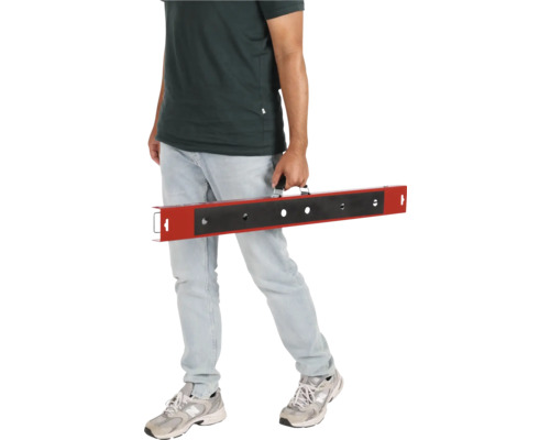 Muž nesie nivelačnú tyč