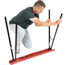 Muž obsluhuje nosnú pomôcku pre sadrokartónové dosky