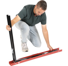 Muž montuje kovové šablóny na rezanie dlaždíc pre veľké dlaždice