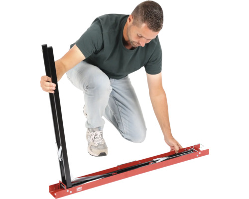 Muž montuje kovové šablóny na rezanie dlaždíc pre veľké dlaždice