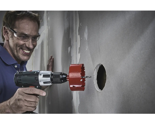 Muž vŕta do steny otvor pomocou dierovacej píly.