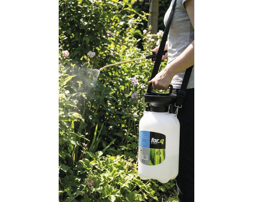 Osoba používa záhradný postrekovač for_q na postrek rastlín.