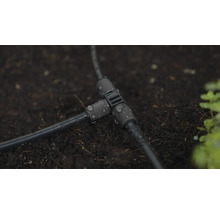 T-kus pre zavlažovací systém na tmavej zemi