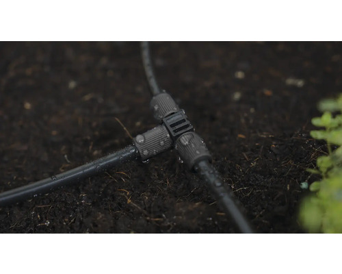 T-kus pre zavlažovací systém na tmavej zemi