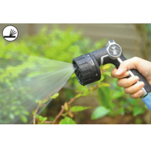 Osoba drží záhradnú striekaciu pištoľ, ktorá strieka vodu