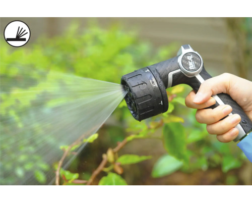 Osoba drží záhradnú striekaciu pištoľ, ktorá strieka vodu