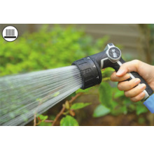 Ruka drží záhradný postrekovač pri zavlažovaní