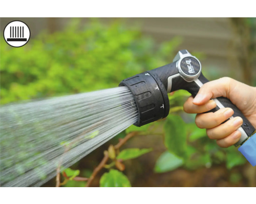 Ruka drží záhradný postrekovač pri zavlažovaní