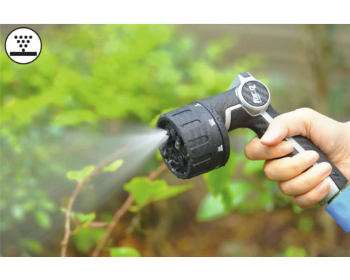 Ruka drží záhradnú striekaciu pištoľ s prúdom vody