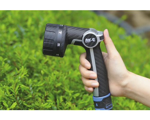 Ruka drží záhradný postrekovač značky for_q.