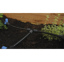 Zavlažovací systém s hadicami a spojkami v záhradnom záhone