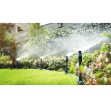 Zavlažovací systém v záhrade s trávnikovými postrekovačmi v prevádzke