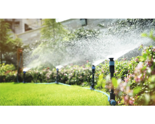 Zavlažovací systém v záhrade s trávnikovými postrekovačmi v prevádzke