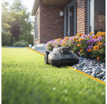 Robotická kosačka na trávniku pred domom