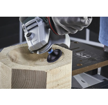 Obrábanie dreva uhlovou brúskou tvaruje misu v drevenom bloku.