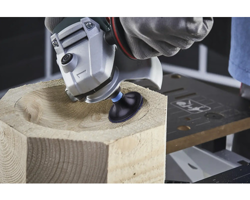 Obrábanie dreva uhlovou brúskou tvaruje misu v drevenom bloku.