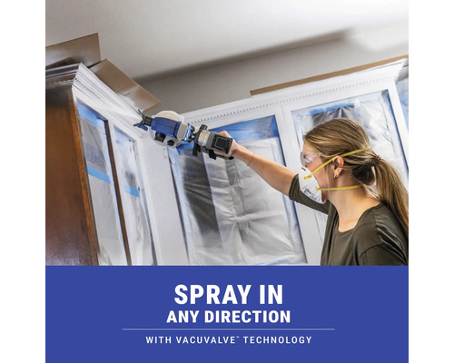 Žena používa striekaciu pištoľ s technológiou Vacuvalve na natieranie skriniek.