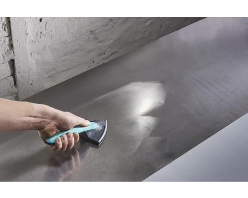 Ruka používa brúsny blok na vyhladenie kovového povrchu.