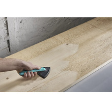 Ruka brúsi drevenú dosku trojuholníkovou brúskou