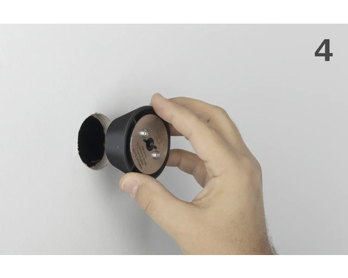 Ruka drží vrták na hmoždinky Wolfcraft pred vyvŕtaným otvorom.