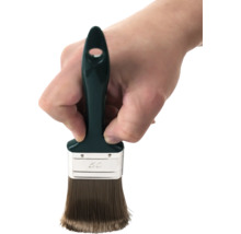 Ruka drží plochý štetec so šírkou 50 milimetrov