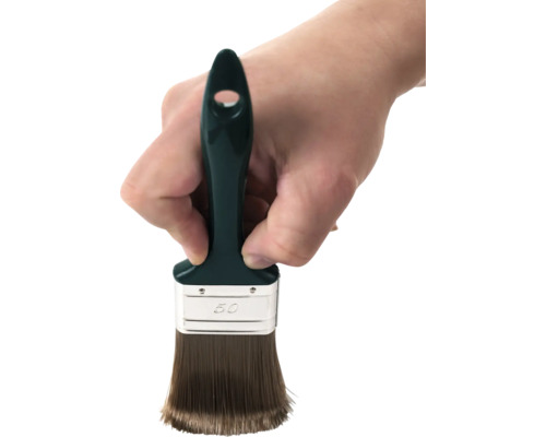 Ruka drží plochý štetec so šírkou 50 milimetrov