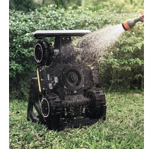 Zavlažovaný záhradný robot s pásovým pohonom v prevádzke na trávniku.
