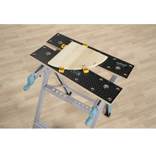 Pracovný stôl Wolfcraft Master 200 s kusom dreva a upínacími čeľusťami.