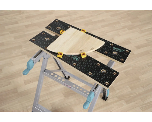 Pracovný stôl Wolfcraft Master 200 s kusom dreva a upínacími čeľusťami.