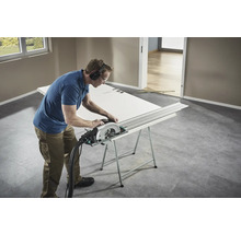 Remeselník reže dvere ručnou okružnou pílou na pracovnom stole.