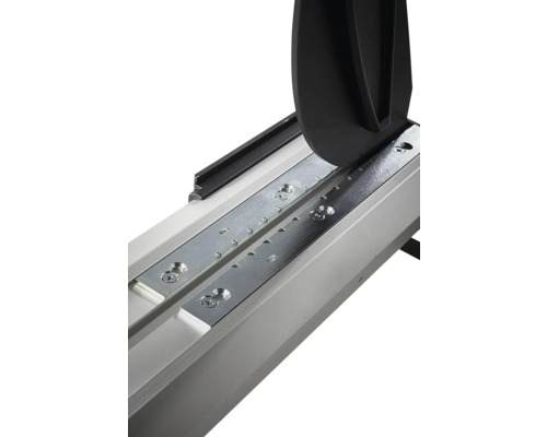 Detail rezačky na obklady s vodiacou lištou, kovovými doskami a lámacím mechanizmom.