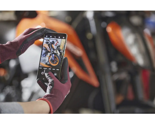 Smartfón v rukaviciach fotí motorku.