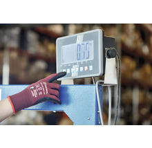 Osoba obsluhuje digitálnu priemyselnú váhu s pracovnou rukavicou