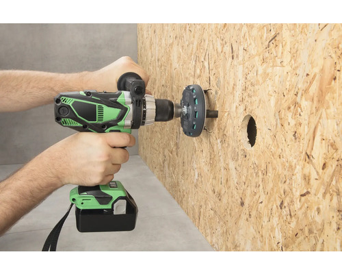 Osoba vŕta otvor do drevenej dosky pomocou akumulátorového vŕtacieho skrutkovača.