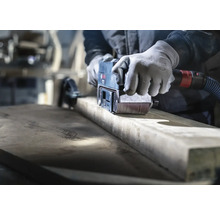 Remeselník brúsi drevo pásovou brúskou