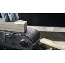 Detail pásovej brúsky brúsiaci kus dreva