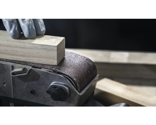 Detail pásovej brúsky brúsiaci kus dreva