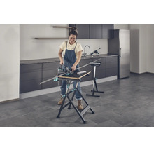 Žena pracuje s pracovným stolom a pokosnicou v miestnosti.