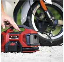 Červený akumulátorový kompresor Einhell pred motocyklom