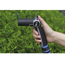 Ruka drží záhradnú striekaciu pištoľ značky For Q pred zeleným kríkom