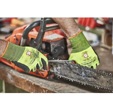 Osoba obsluhujúca reťazovú pílu s ochrannými rukavicami.