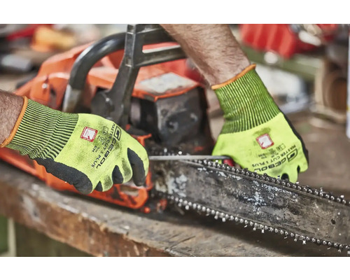 Osoba obsluhujúca reťazovú pílu s ochrannými rukavicami.