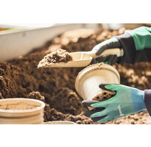 Záhradnícka scéna s lopatkou na rastliny, kvetináčom a zeminou