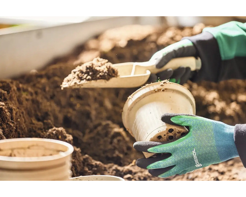 Záhradnícka scéna s lopatkou na rastliny, kvetináčom a zeminou